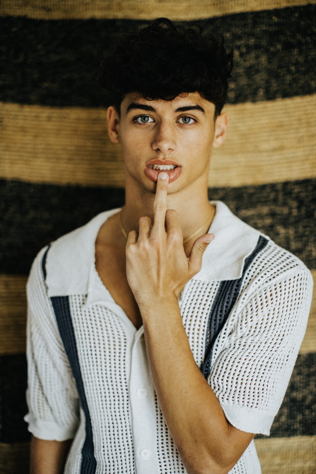 Bright editorial portrait of male model with curly hair, by Tony Liam