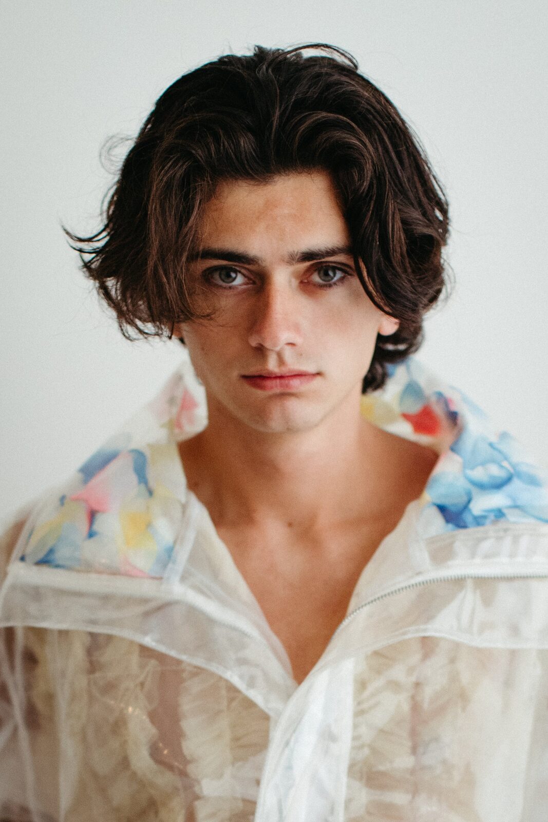 Direct gaze headshot of male model in sheer floral jacket by Tony Liam
