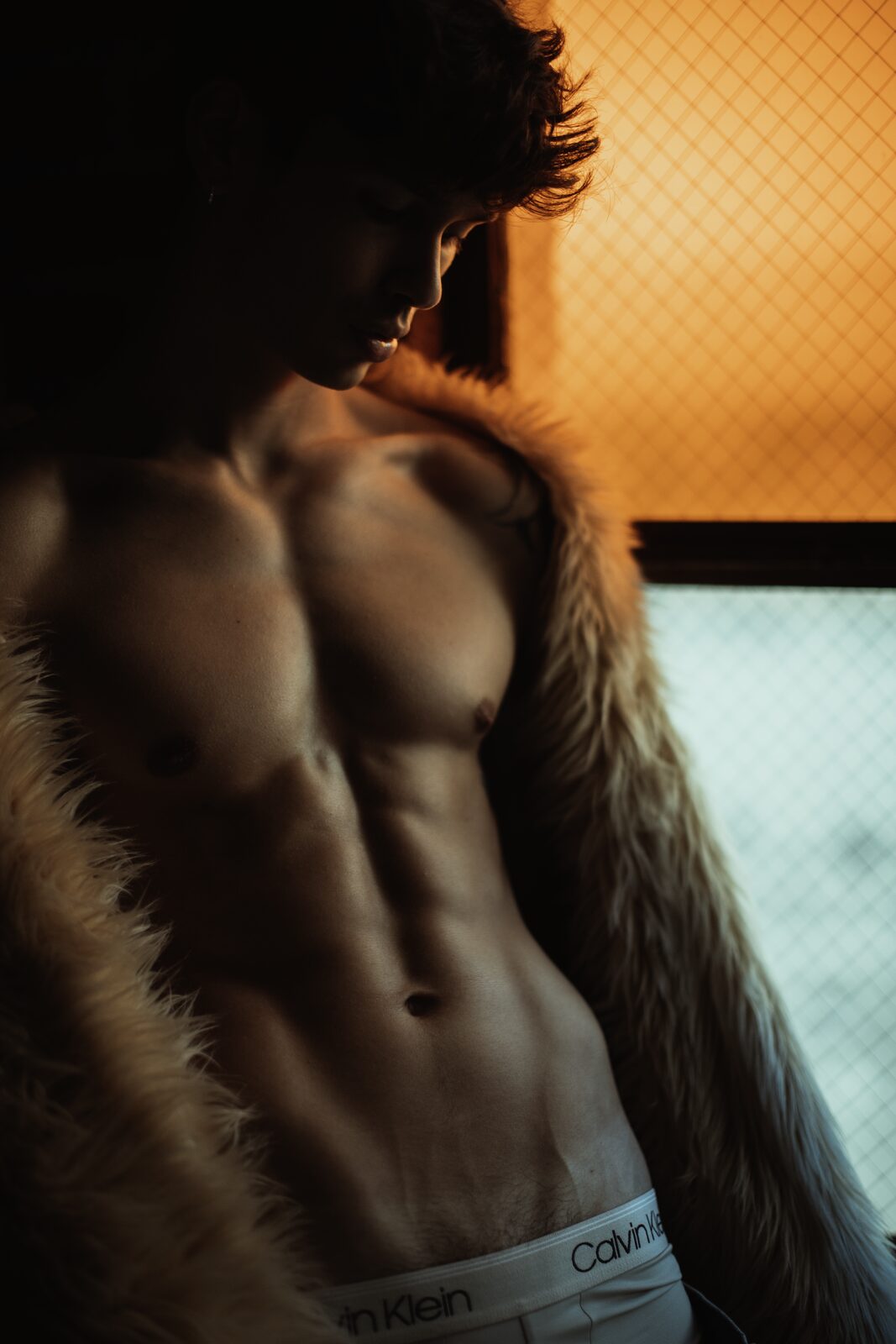 Male model in profile wearing fur coat, editorial fashion photography by Tony Liam