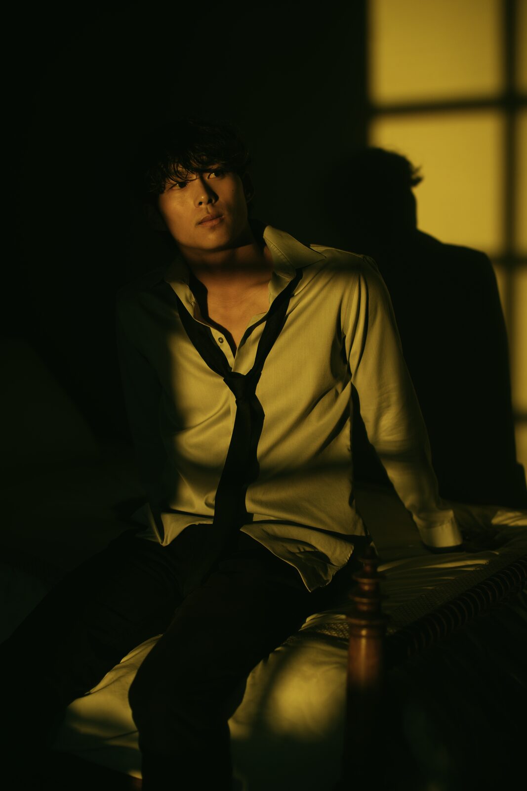 Cinematic male model portrait in golden window light with loose tie, by Tony Liam